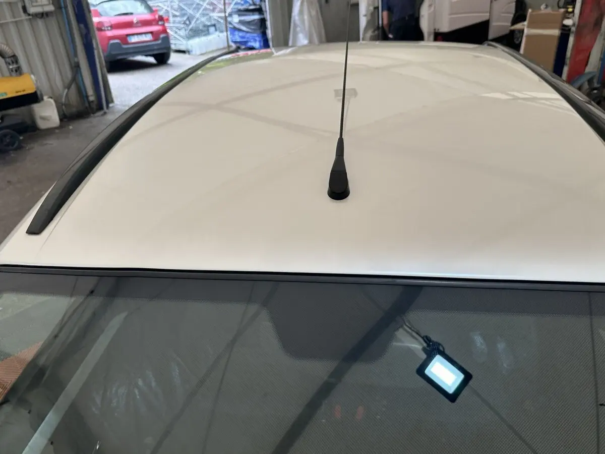 Vue plongeante sur le toit blanc d'une Aixam Ambition 0.5 Crossover Premium 2026 avec antenne centrale.