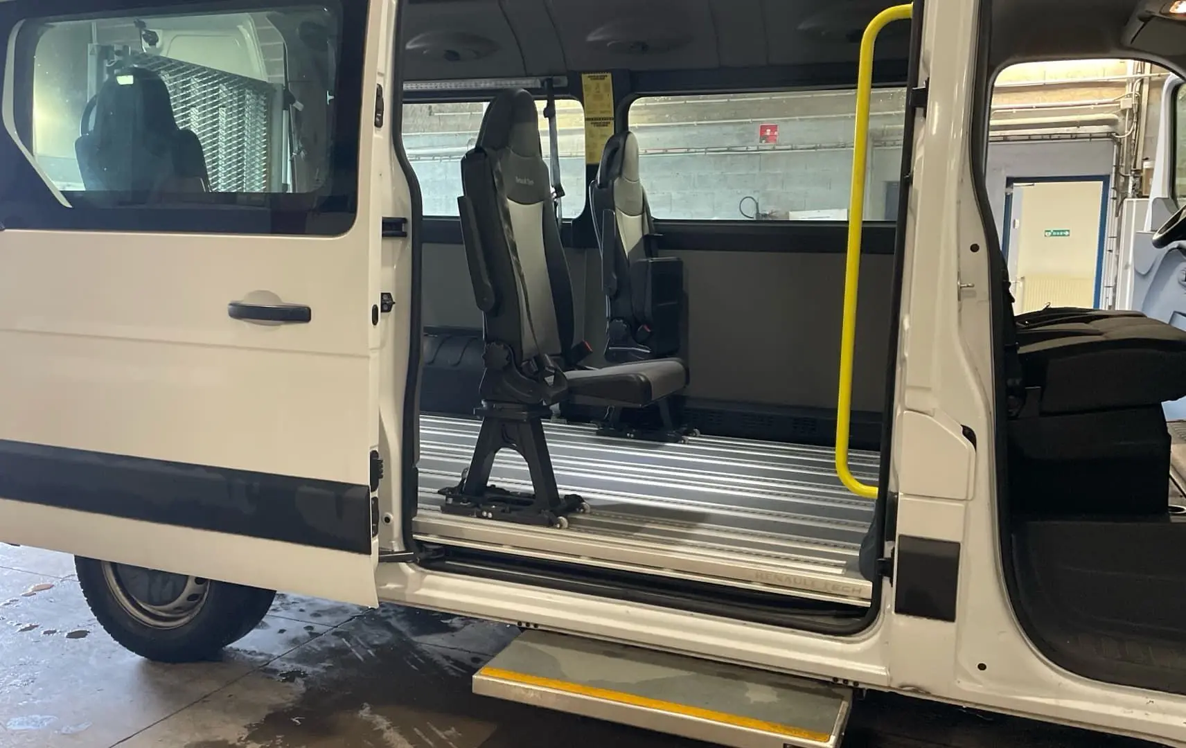 Vue latérale gauche du Renault Master blanc 2020 avec porte latérale ouverte, marchepied déployé et sièges modulables à l'intérieur.