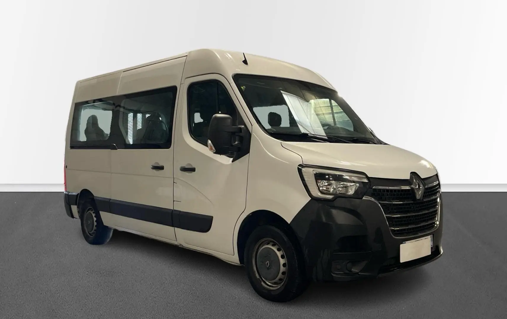 Renault Master blanc en 3/4 avant droit, fourgon TPMR avec grandes fenêtres latérales et marchepied visible.