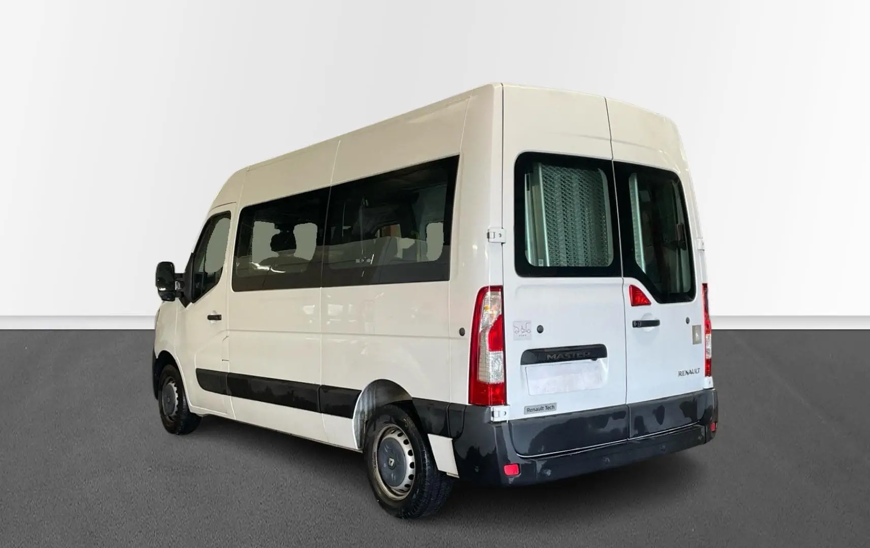 Vue 3/4 arrière droite d’un Renault Master blanc avec vitres latérales teintées et porte arrière vitrée.