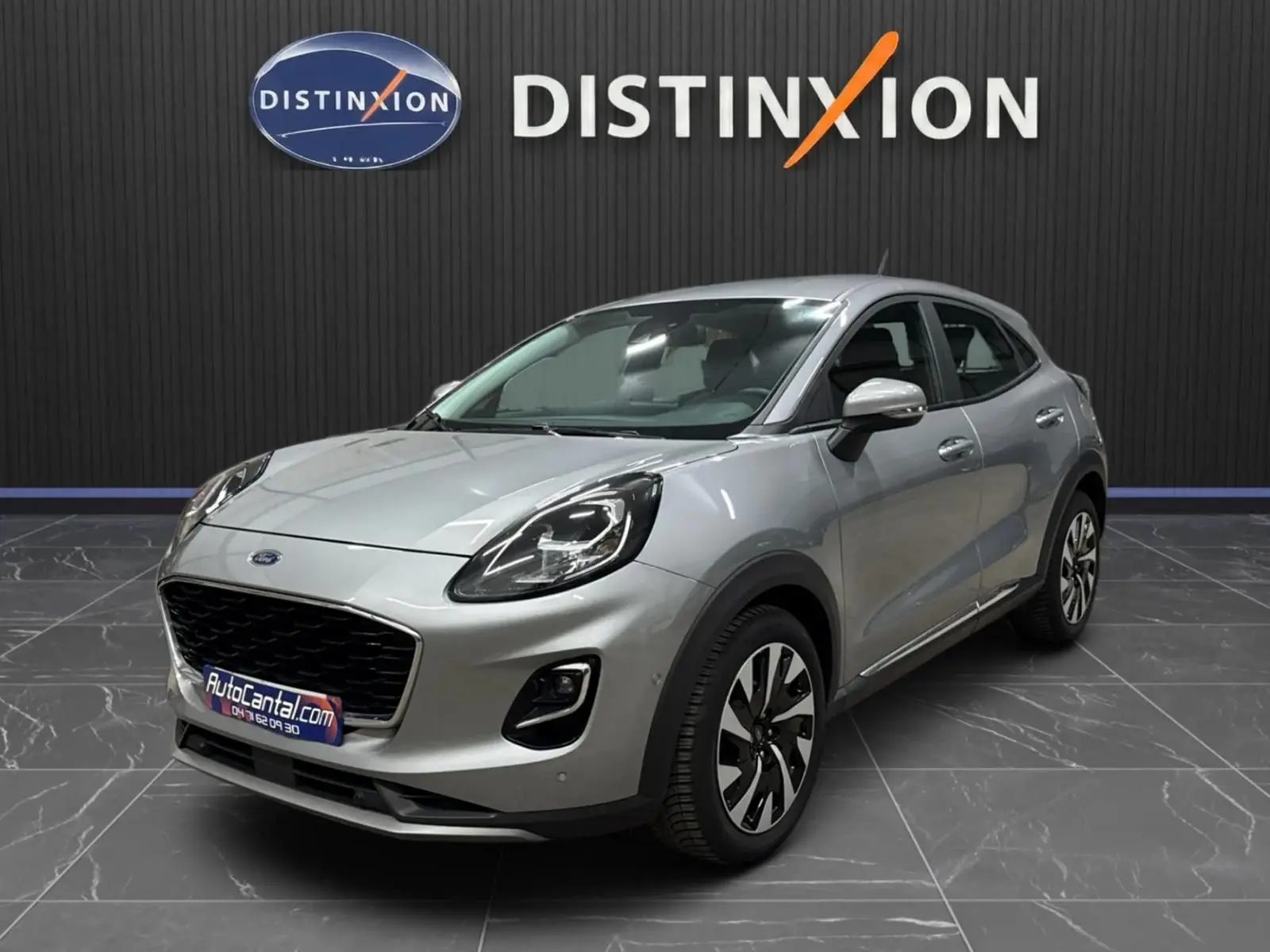 Ford Puma gris solar en vue 3/4 avant droit, avec calandre noire et jantes alliage distinctives.