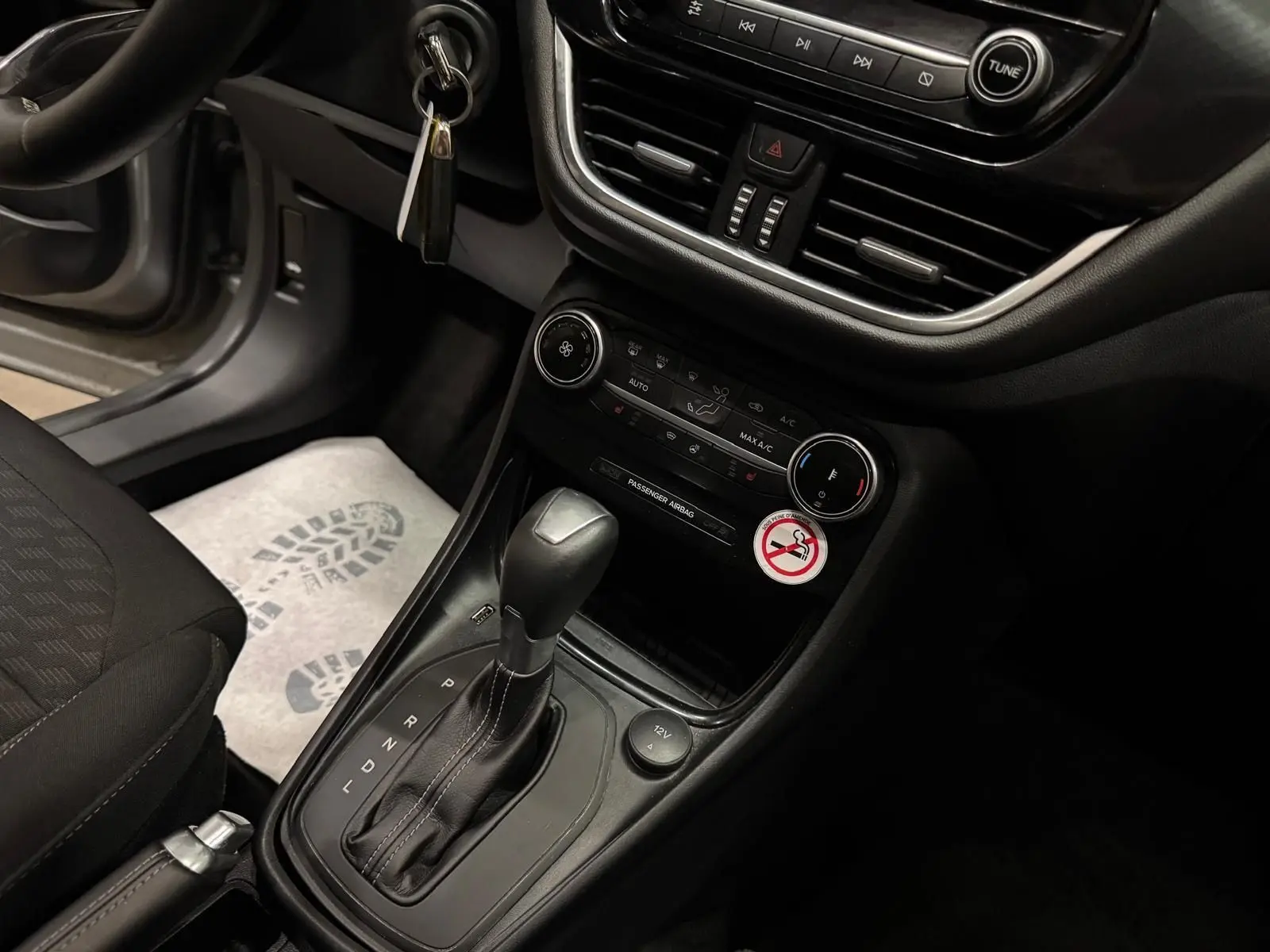Vue rapprochée de la console centrale intérieure du Ford Puma gris, avec levier de boîte auto et commandes de climatisation.