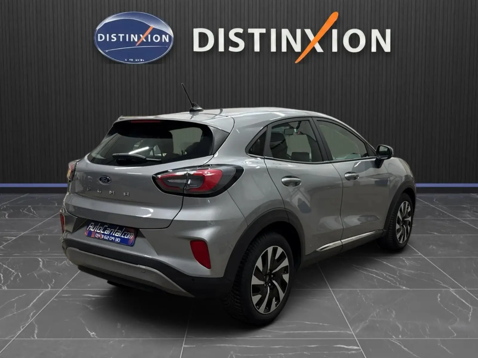 Vue 3/4 arrière droite d'un Ford Puma gris solar 2023 avec jantes alliage et feux LED distinctifs.