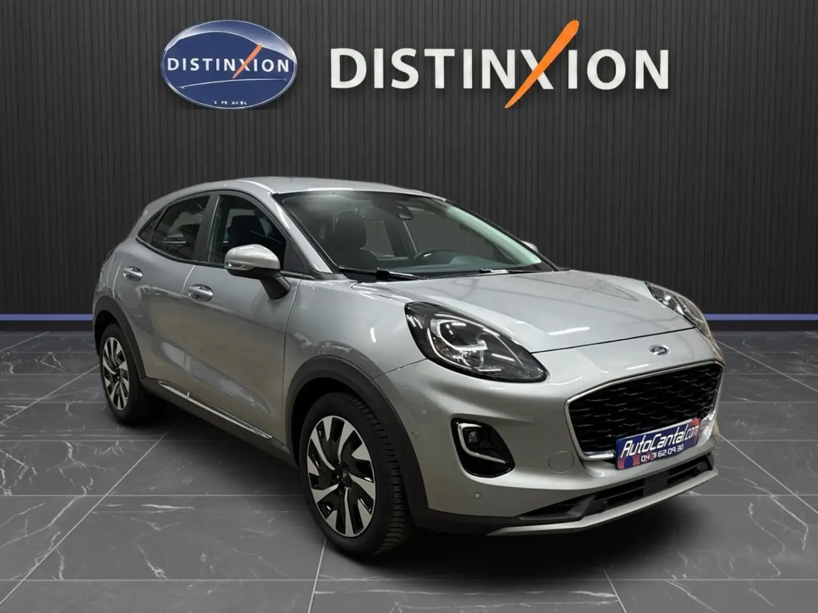 Ford Puma gris solar en 3/4 avant droit, mettant en valeur ses phares LED et sa calandre noire distinctive.