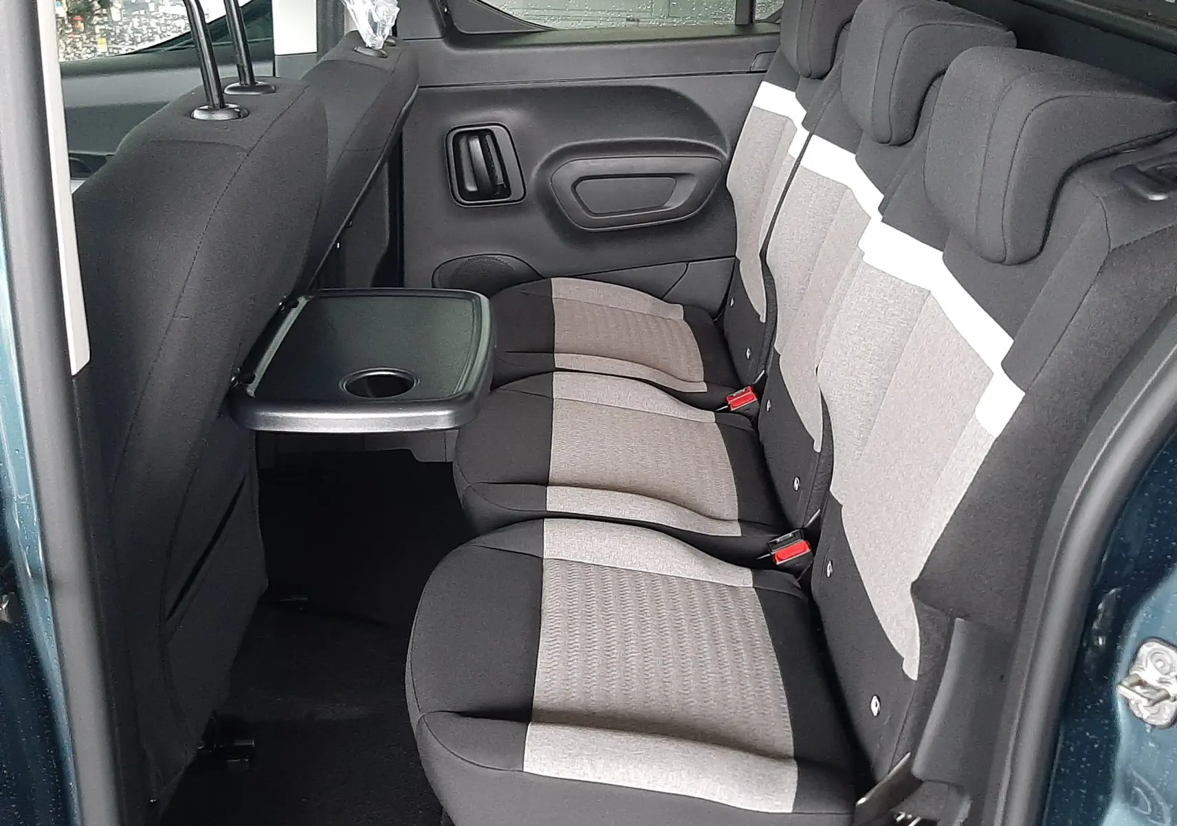 Vue intérieure côté droit du Citroën Berlingo bleu Kiama 2026, montrant la banquette arrière avec tablette rabattable.