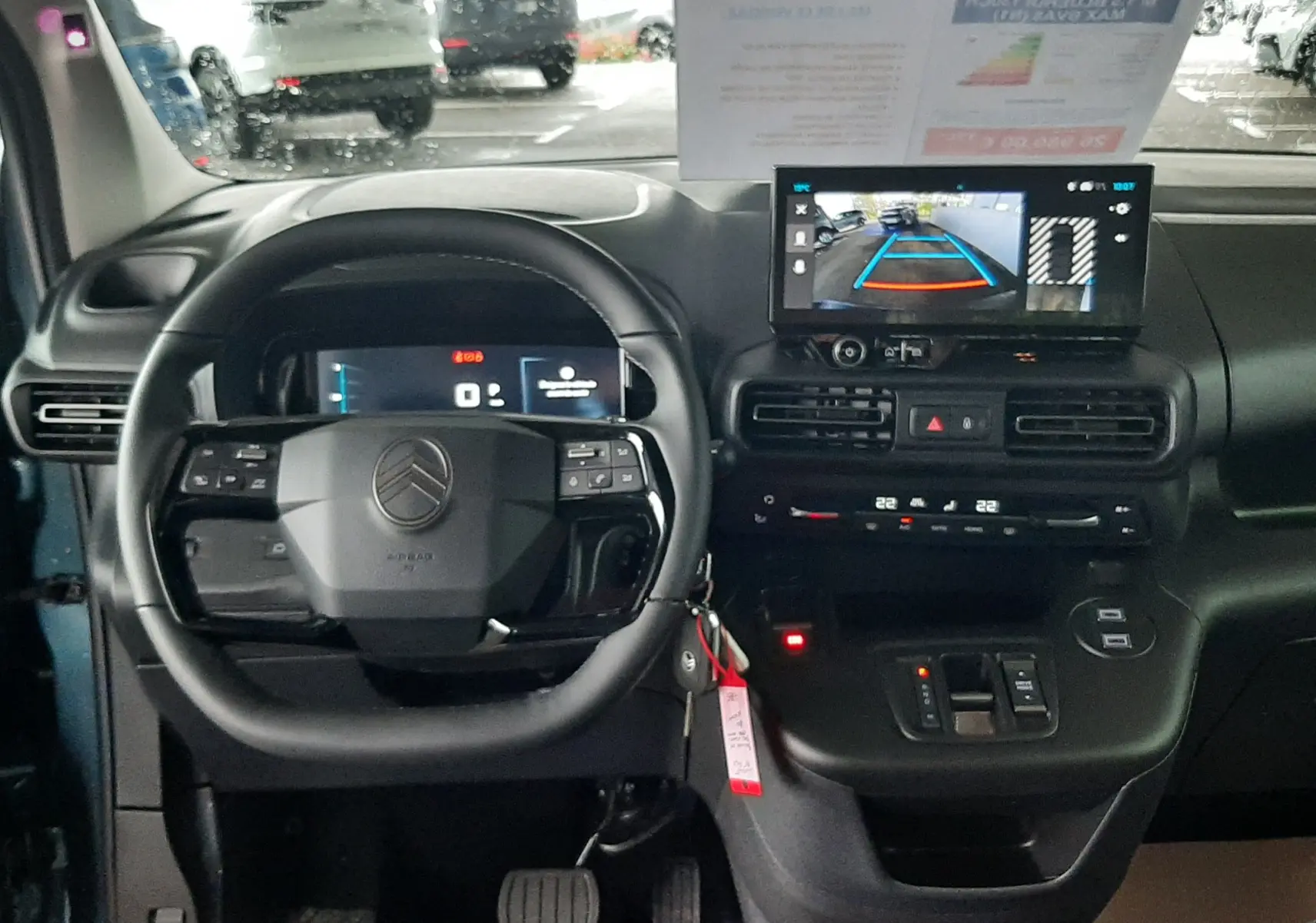 Vue intérieure avant du Citroën Berlingo bleu Kiama 2026, tableau de bord avec écran de caméra de recul et volant multifonction.