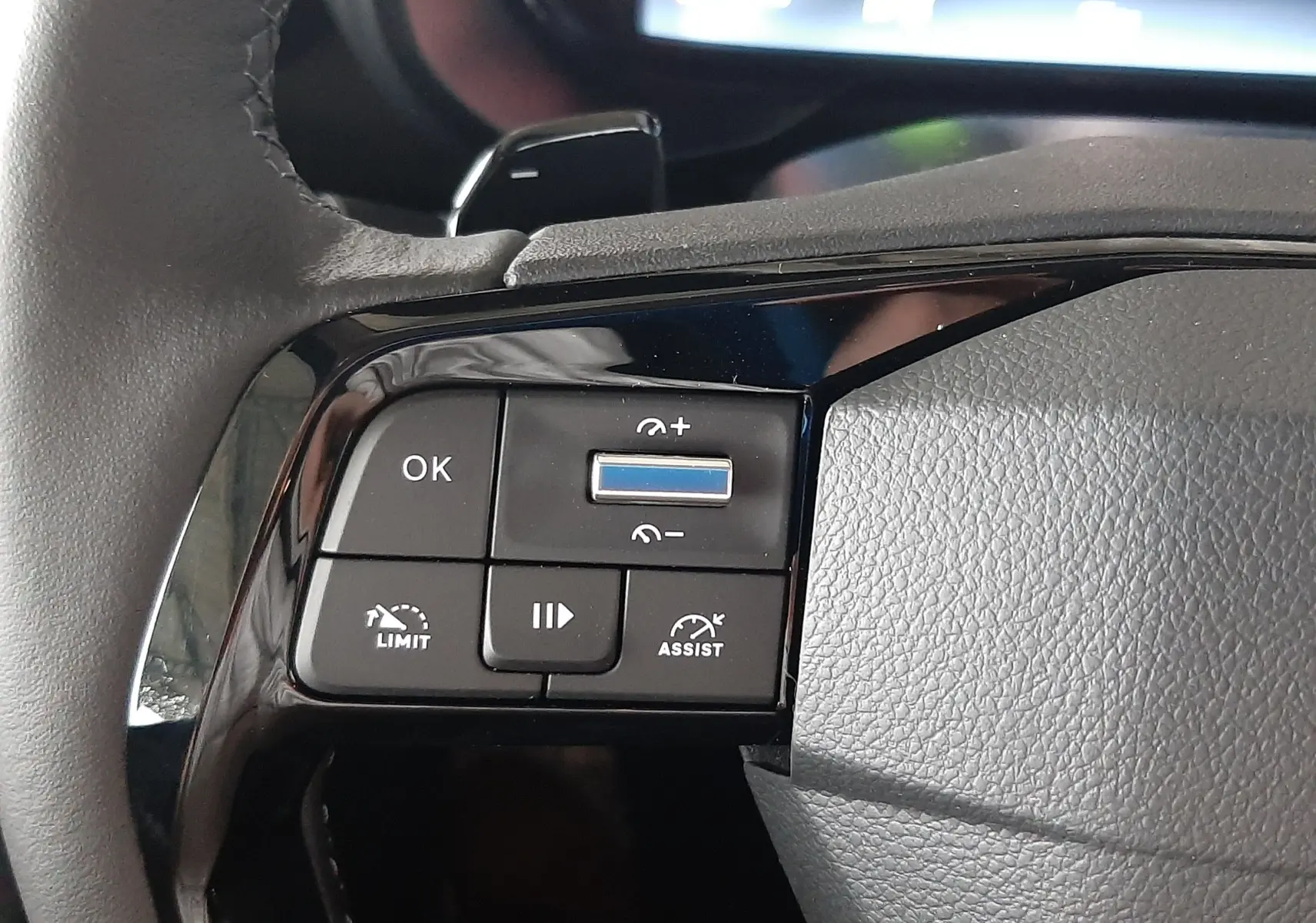 Gros plan sur les commandes au volant noir du Citroën Berlingo 2026, avec boutons de régulateur et assistant de conduite.