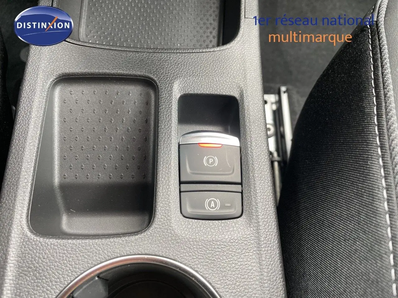 Gros plan sur la console centrale de la Renault Symbioz gris cassiopée, montrant les boutons de frein à main et auto hold.