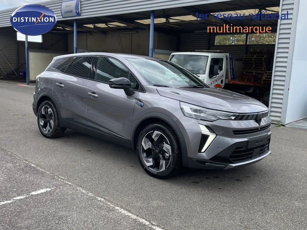 Renault Symbioz gris cassiopée métal, vue 3/4 avant droit, SUV hybride avec jantes modernes et calandre distinctive.