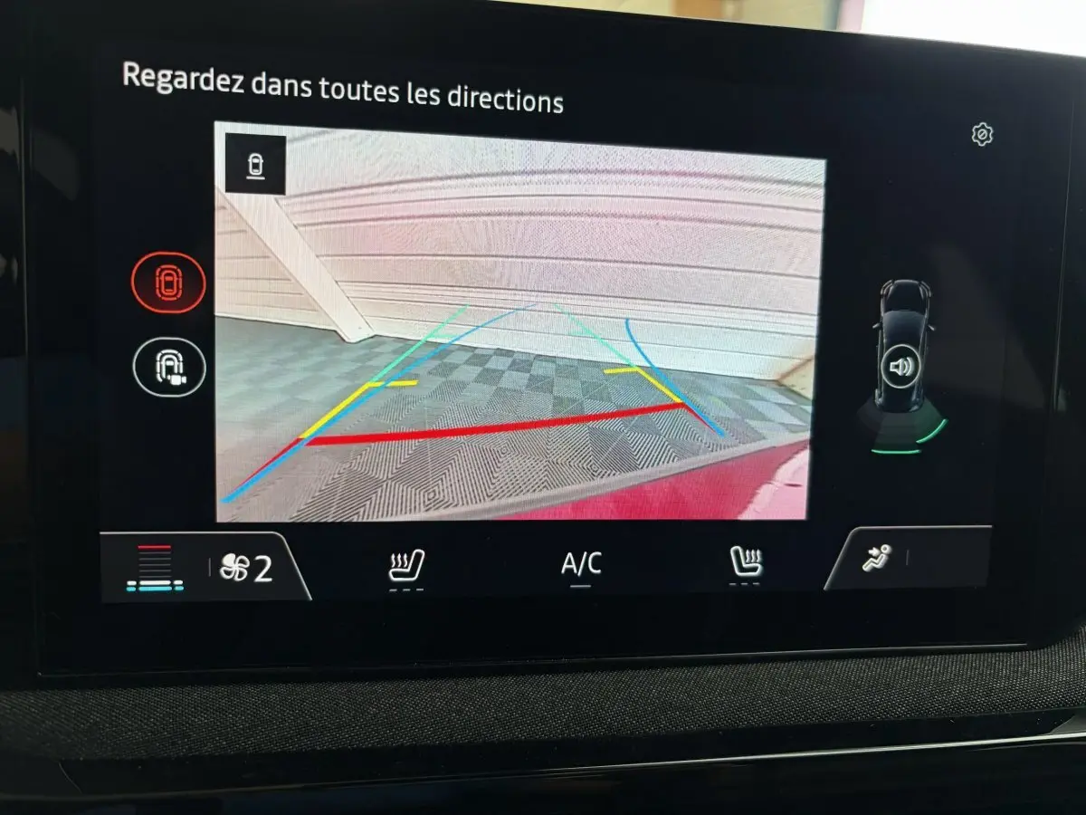 Affichage de la caméra de recul de la Renault Clio rouge 2025, vue arrière avec lignes de guidage colorées.