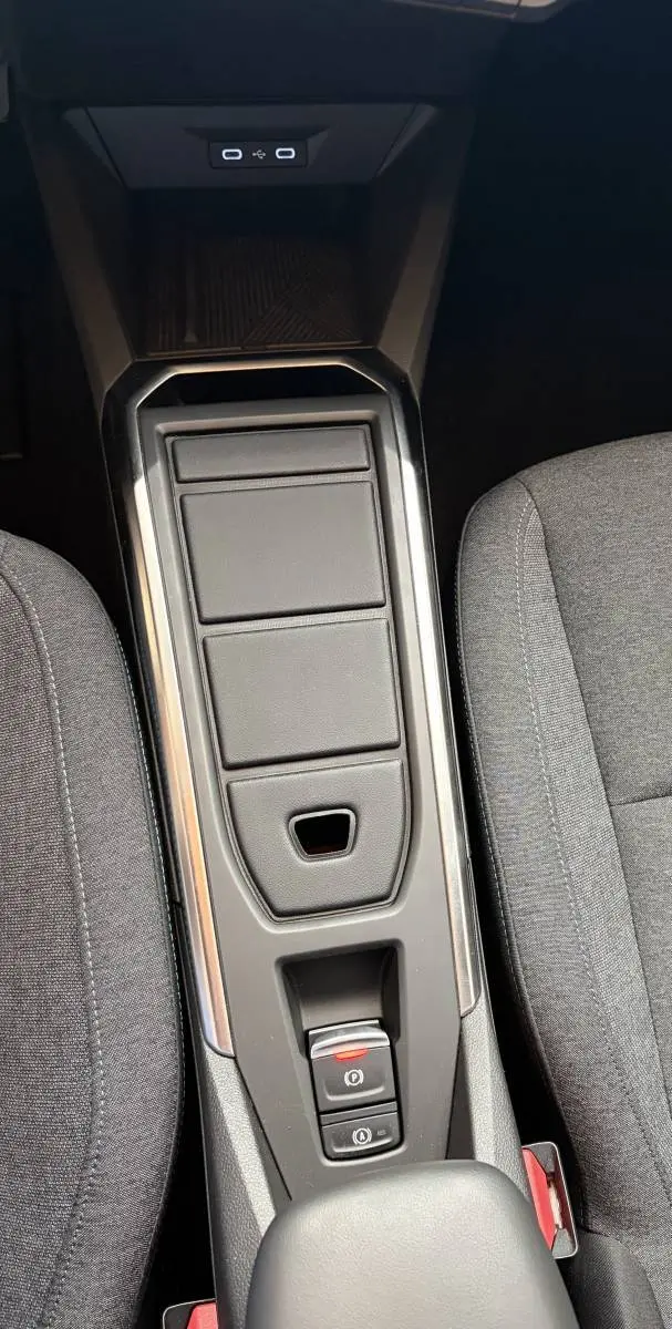 Vue plongeante sur la console centrale noire de la Renault Clio Evolution hybride 2025 avec commandes électroniques et sièges gris.