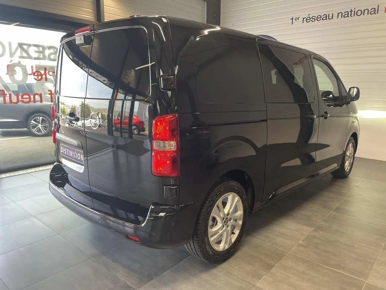Vue 3/4 arrière droite d'un Opel Vivaro noir carbone avec portes arrière battantes et jantes argentées.