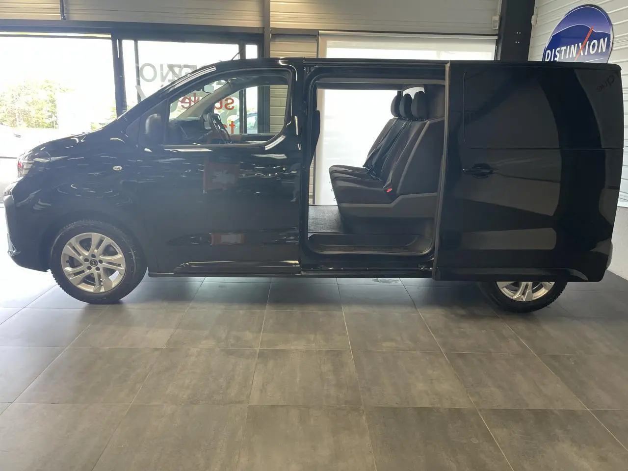 Opel Vivaro noir carbone vu de profil côté gauche avec porte coulissante ouverte révélant la banquette arrière.