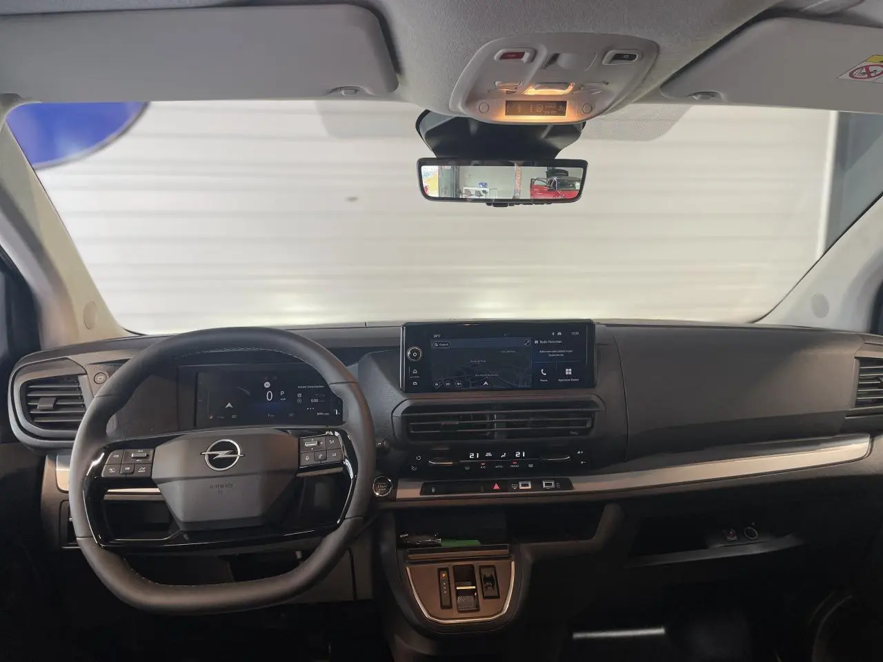 Vue intérieure frontale du tableau de bord noir carbone de l'Opel Vivaro 2025 avec écran tactile et volant multifonction.