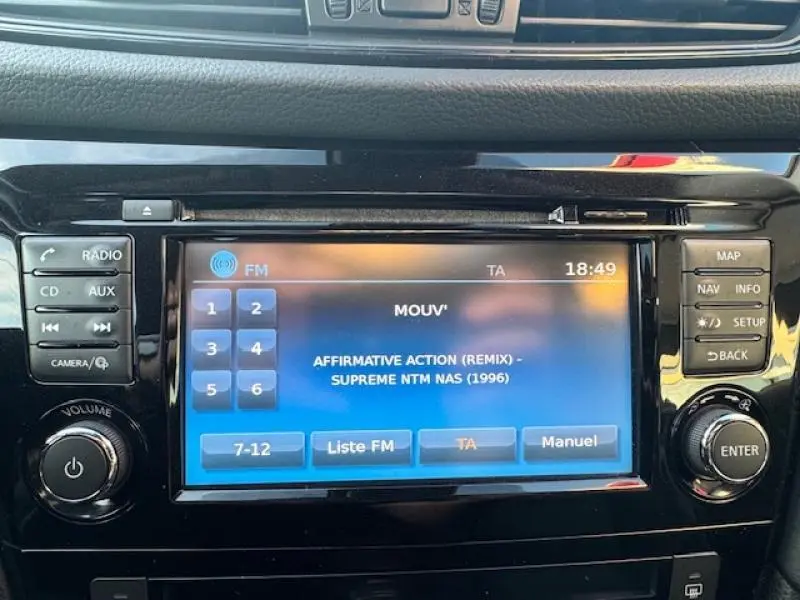 Écran tactile central du Nissan X-Trail noir intense 2018 affichant la radio FM et commandes autour.