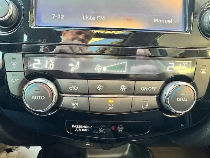 Panneau de climatisation noir brillant du Nissan X-TRAIL 2018 avec affichage digital et commandes rotatives.