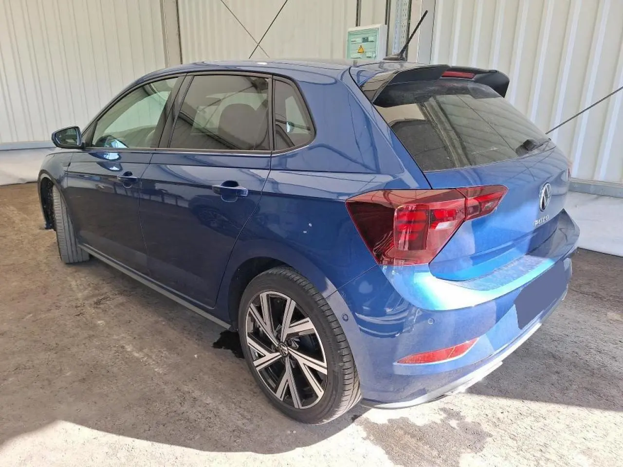 Vue 3/4 arrière droite d'une Volkswagen Polo TSI 95 R-Line bleu récif avec jantes alliage 17 pouces et vitres surteintées.