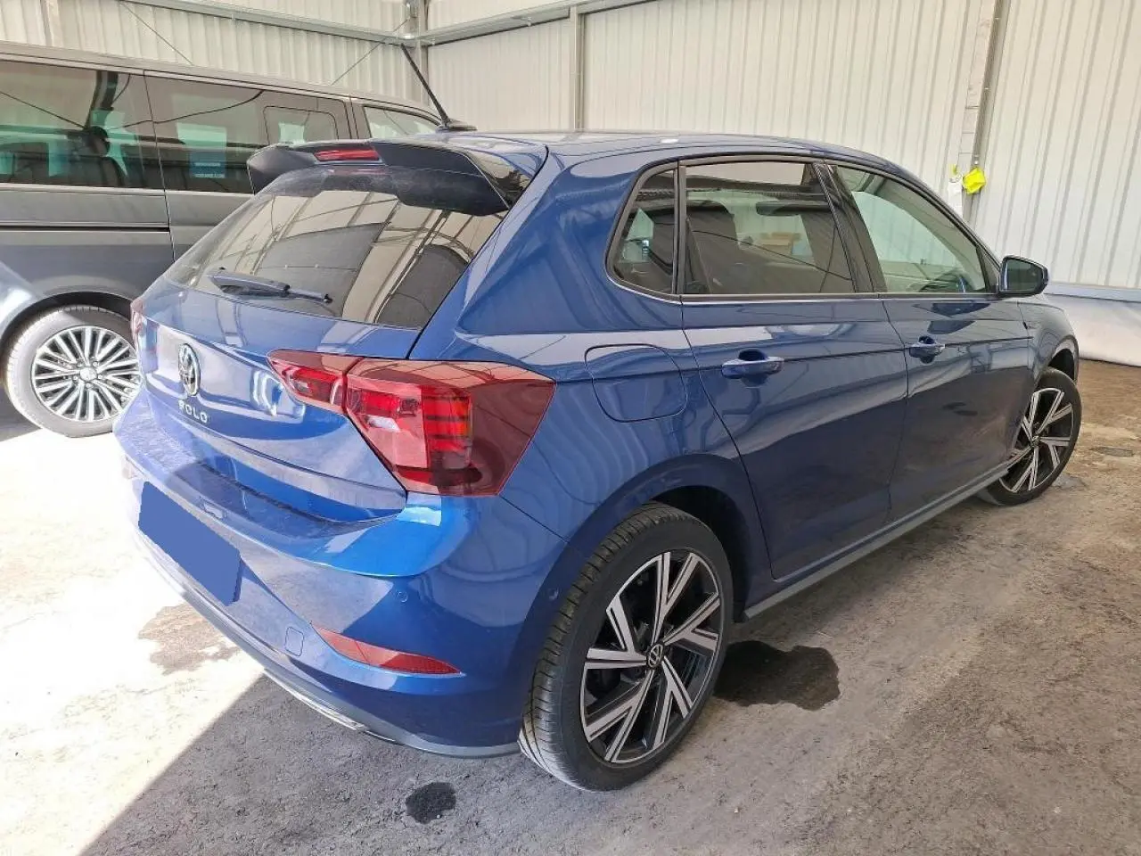 Volkswagen Polo TSI 95 R-Line bleu récif vue 3/4 arrière droit avec jantes alliage 17 pouces et vitres surteintées.