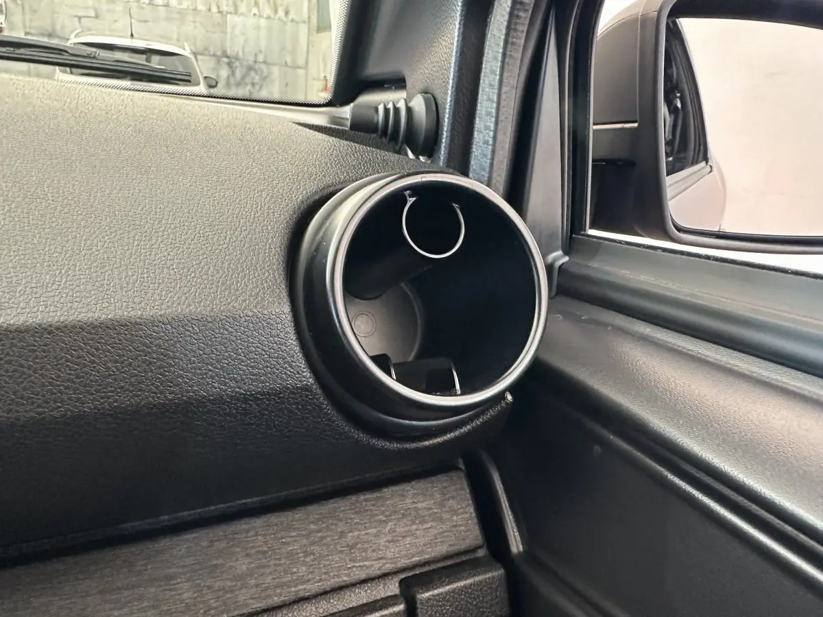 Détail de la console intérieure côté conducteur avec prise ronde et rétroviseur extérieur caméra sur Aixam Ambition bleu 2026.