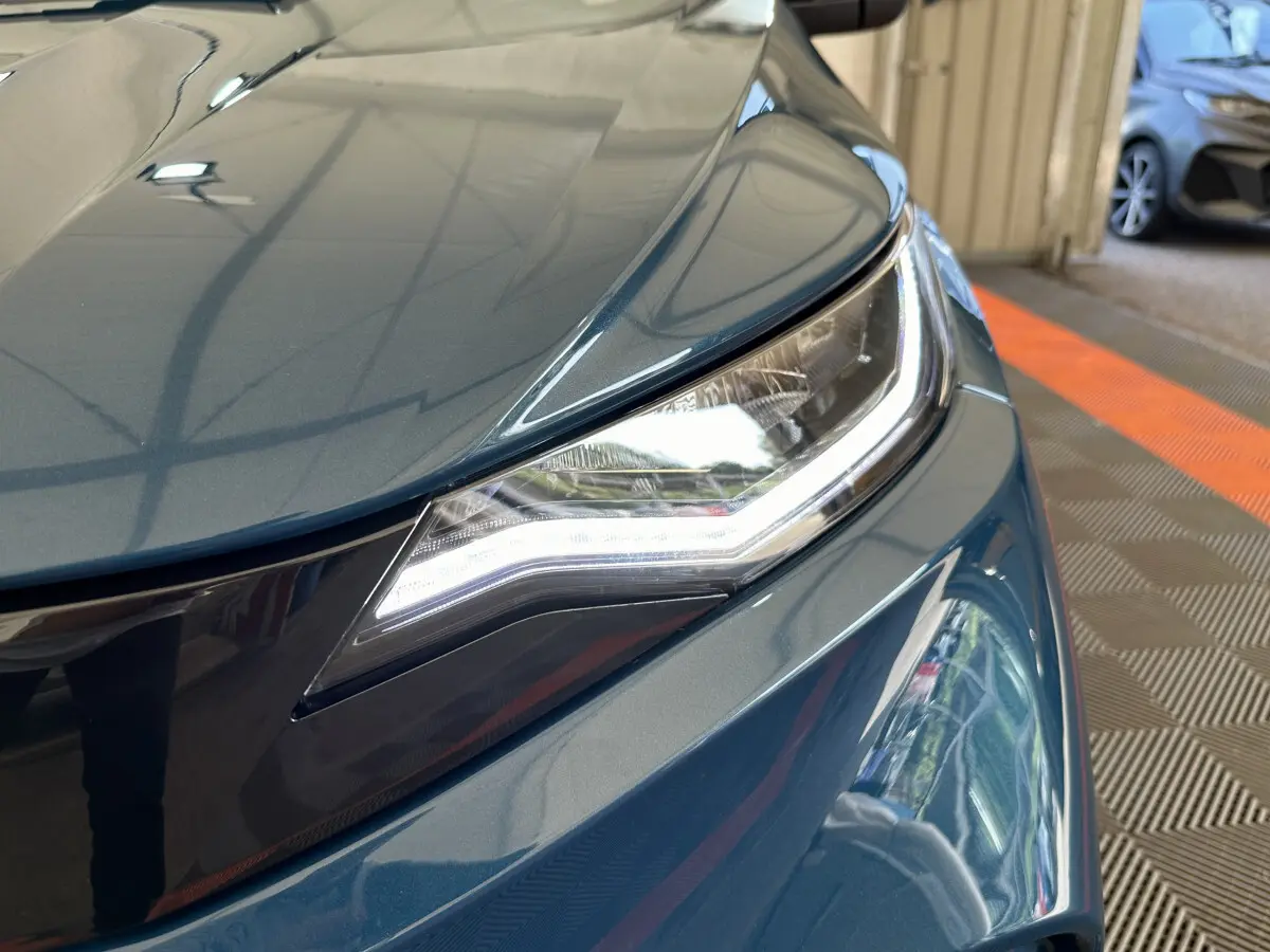 Gros plan sur le phare avant droit bleu de l'AIXAM AMBITION 0.5 CITY PACK 2026 avec éclairage LED distinctif.