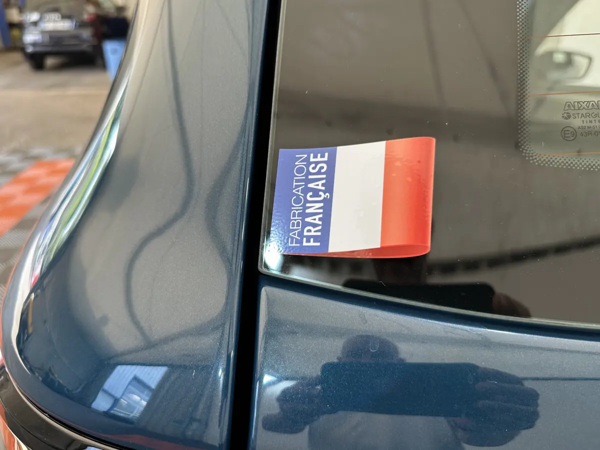Gros plan sur la partie arrière bleue d'une Aixam Ambition 0.5 City Pack avec autocollant "Fabrication Française" sur la vitre.