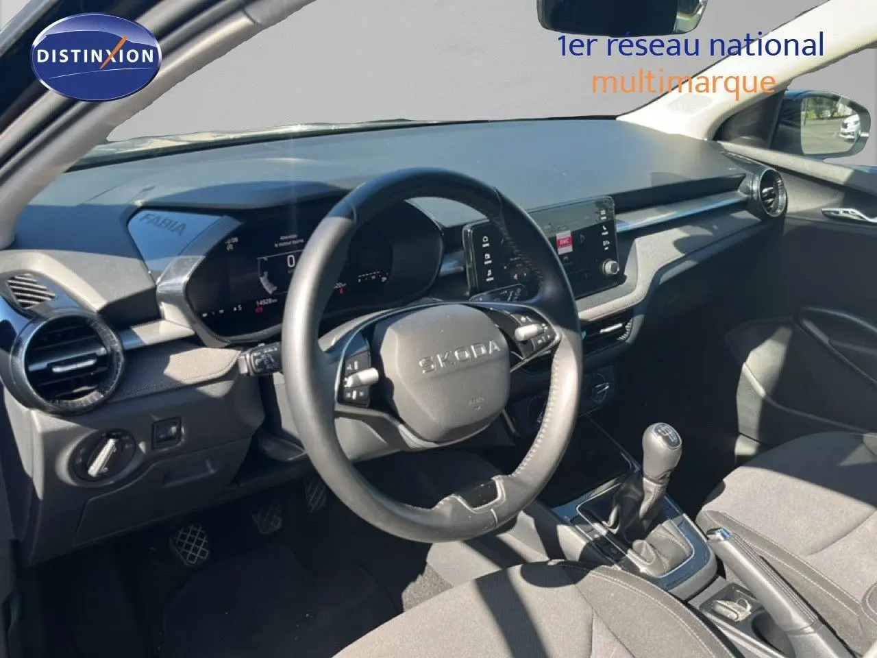 Vue intérieure côté conducteur de la Skoda Fabia 2025 noire, montrant le volant multifonction et la console avec boîte manuelle.