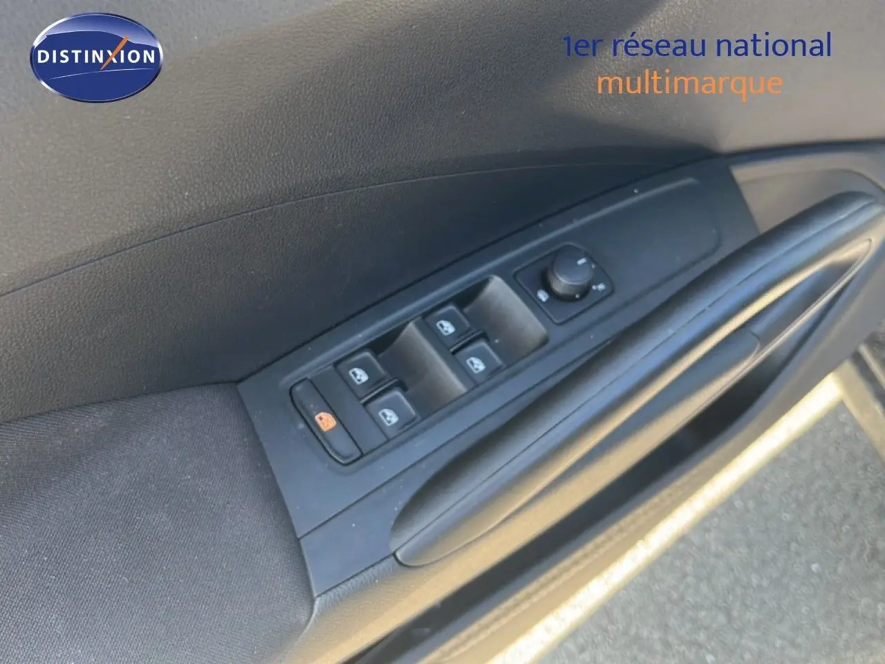 Détail de la commande des vitres électriques sur la porte côté conducteur d'une Skoda Fabia noire.