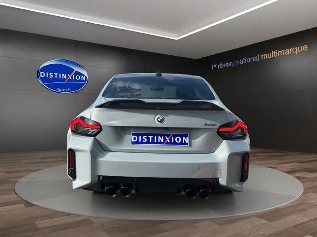 Vue arrière d'une BMW M2 G87 gris Brooklyn Grau avec double sortie d'échappement et logo M sur hayon.