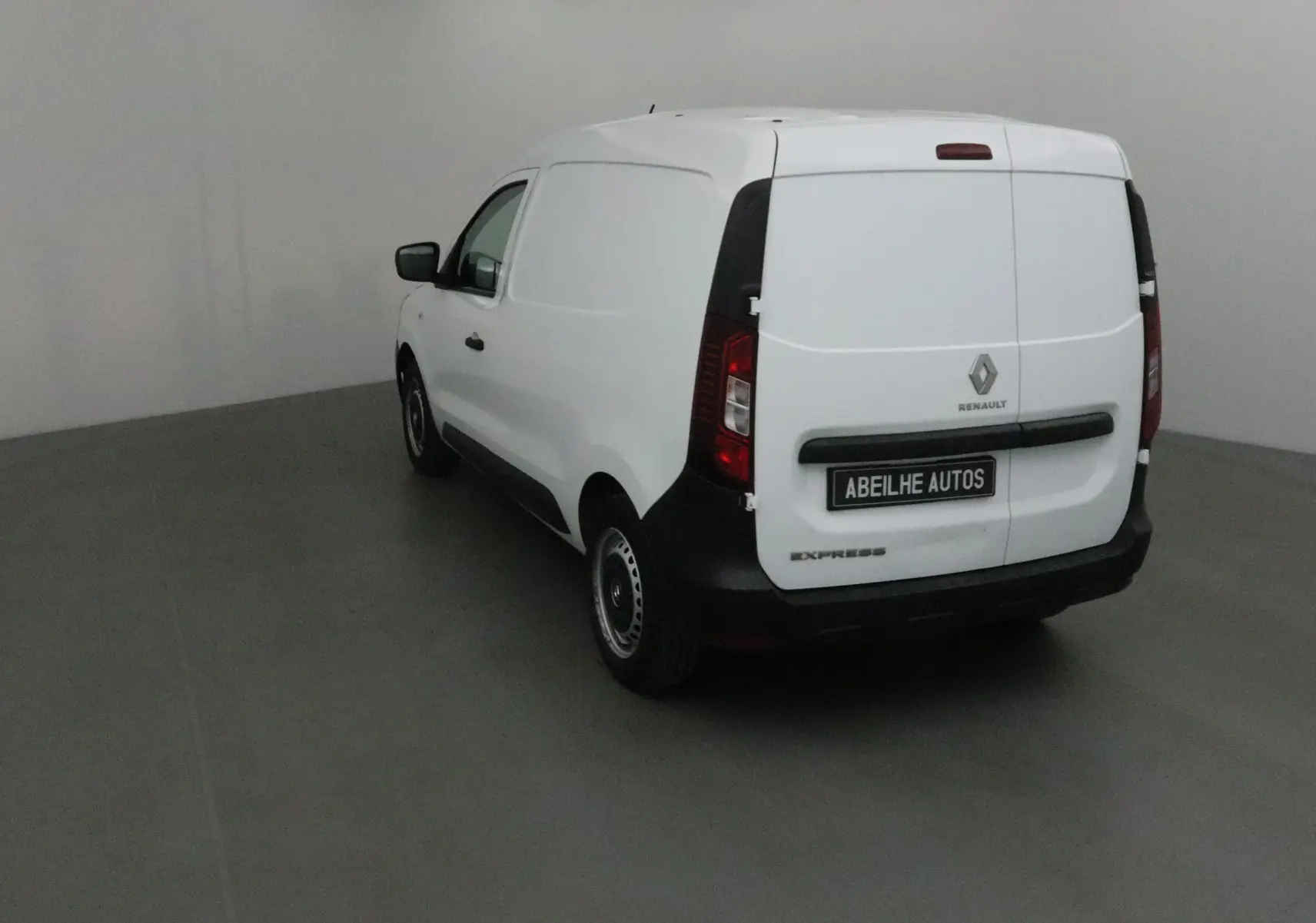 Renault Express Van blanc vu en 3/4 arrière droit, fourgon compact avec porte arrière pleine et logo Renault visible.