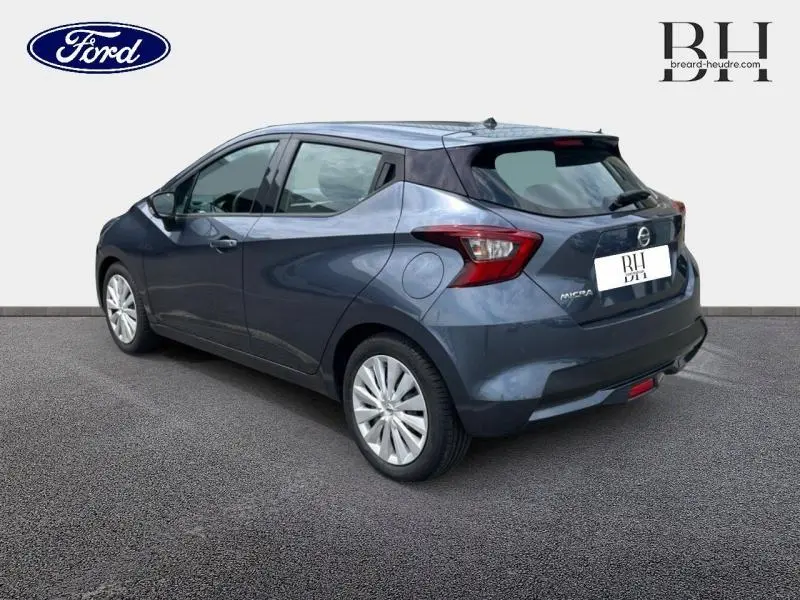 Vue 3/4 arrière droite d'une Nissan Micra gris acier 2022 avec becquet arrière et jantes argentées.