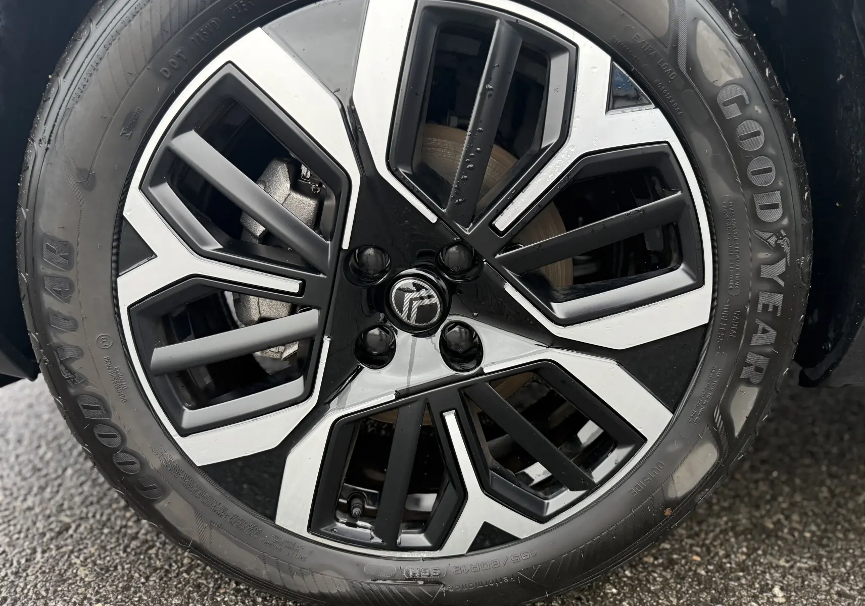 Gros plan sur la jante noire et argentée d’une Citroën C4 Hybrid 145 e-DCS6 Max blanche, pneu Goodyear visible.