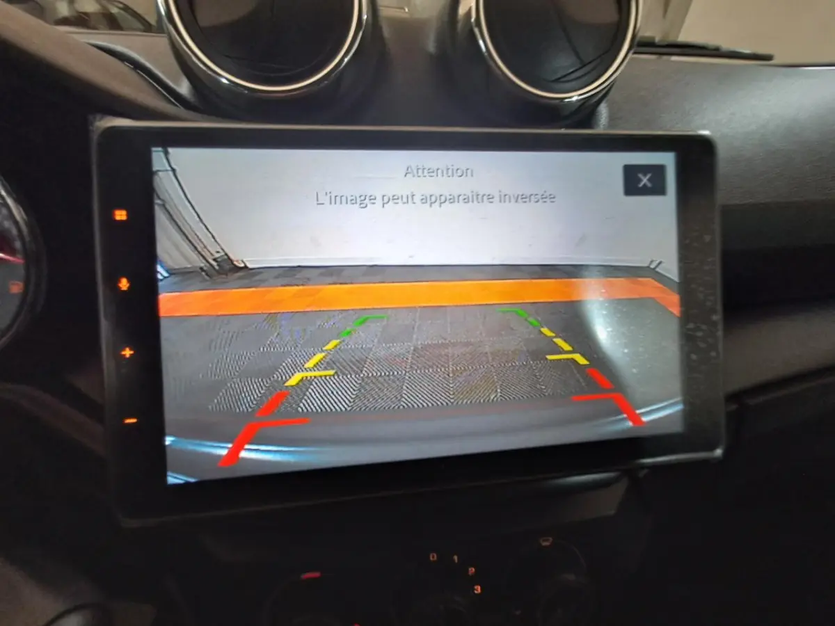 Écran central montrant l'image de la caméra de recul avec guidage coloré dans l'Aixam Ambition gris clair 2024.