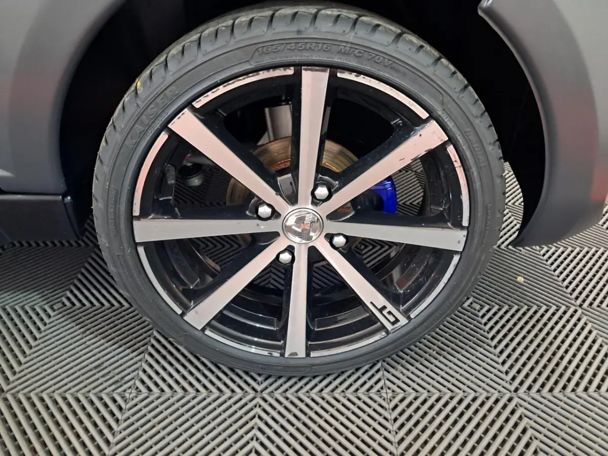 Gros plan sur la jante alliage 16’’ noires diamantées avec logo GT de l’AIXAM AMBITION gris clair 2024.