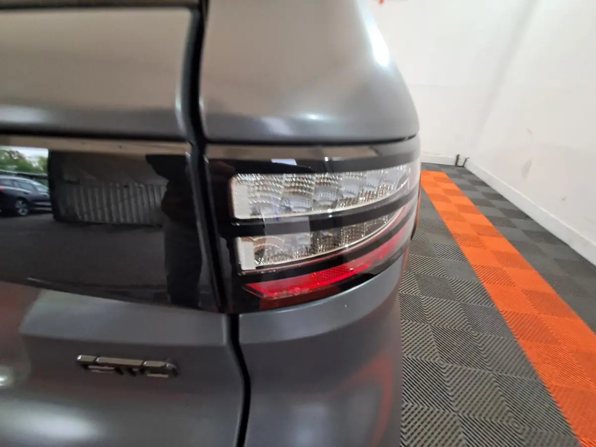 Gros plan sur le feu arrière droit gris clair de l'AIXAM AMBITION 0.5 CITY GTO avec logo GTO visible.