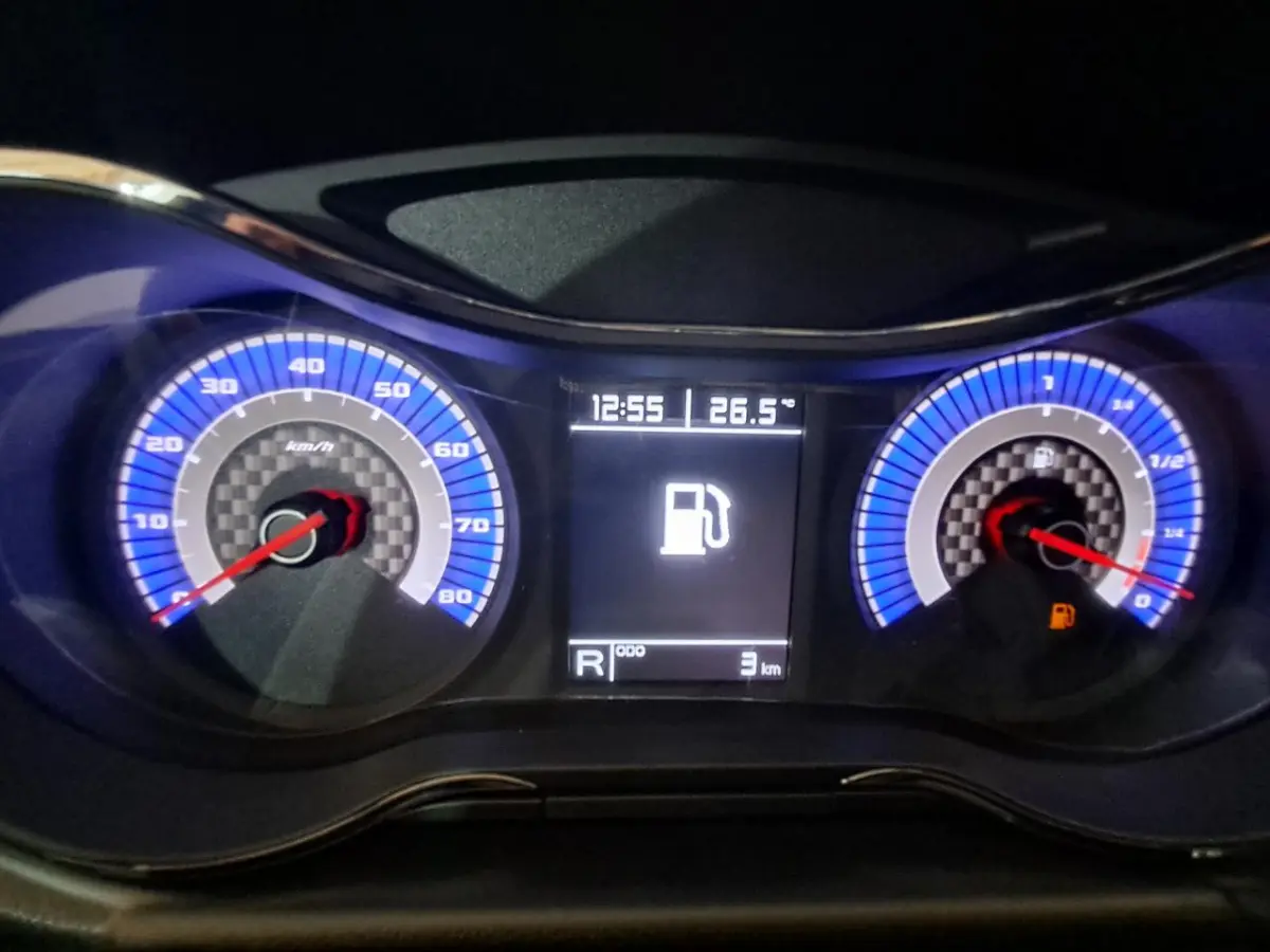 Tableau de bord éclairé en bleu de l'Aixam Ambition 2024, affichant vitesse, jauge carburant et écran central numérique.