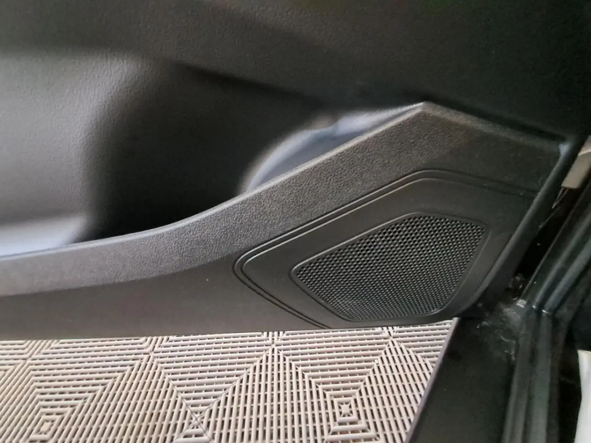 Gros plan sur le panneau de porte intérieur noir de l’Aixam Ambition 2024, mettant en valeur l’enceinte intégrée.