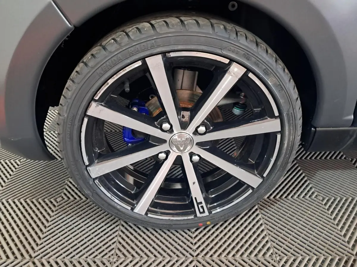 Gros plan sur la jante alliage 16’’ noires diamantées avec logo GT, sur roue d’Aixam Ambition gris clair 2024.