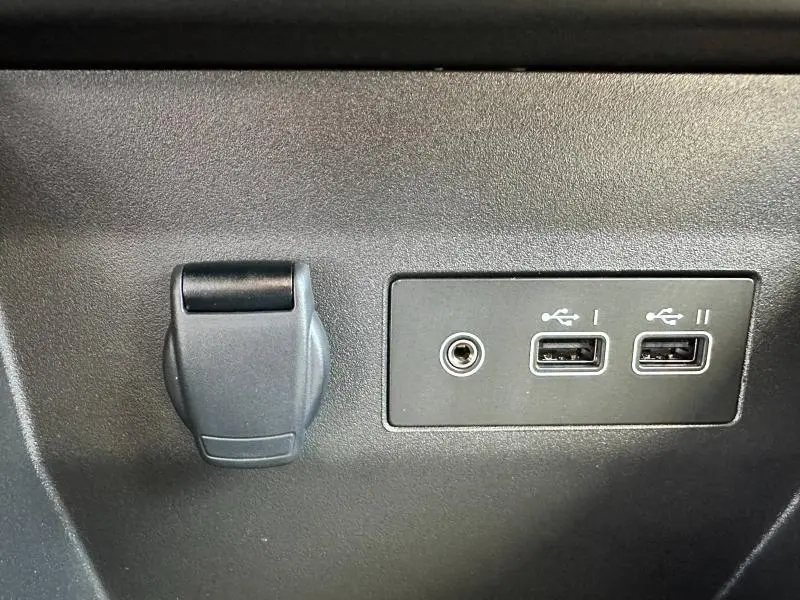 Prise 12V et double port USB noirs intégrés dans la console intérieure d'une Renault Clio Gris Rafale 2025.