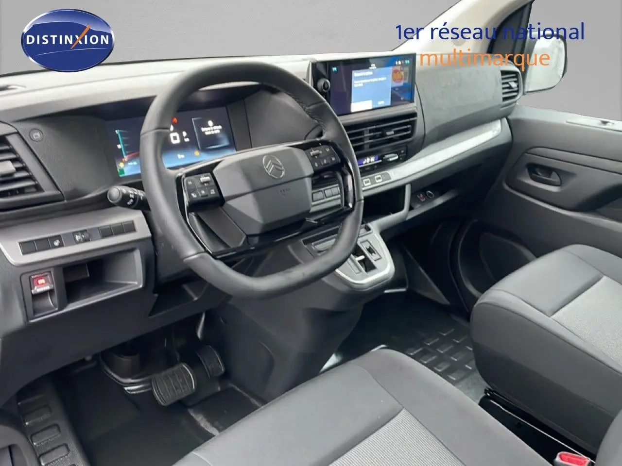 Vue intérieure du poste de conduite du Citroën Jumpy Cabine Approfondie gris titane, avec tableau de bord et volant multifonction.