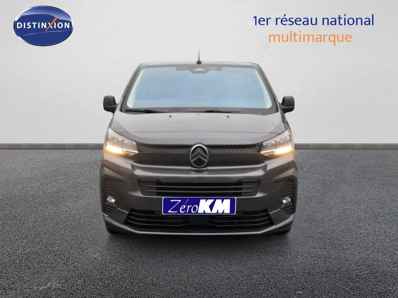 Vue de face du Citroën Jumpy Cabine Approfondie gris titane métal avec feux allumés sur fond neutre.