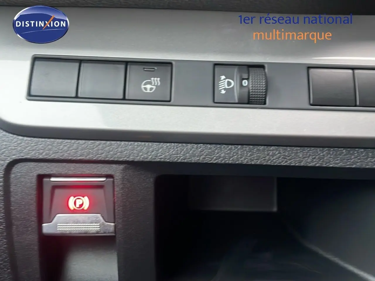 Gros plan sur les commandes du tableau de bord du Citroën Jumpy Long L3 gris titane, avec bouton de frein à main électronique allumé.