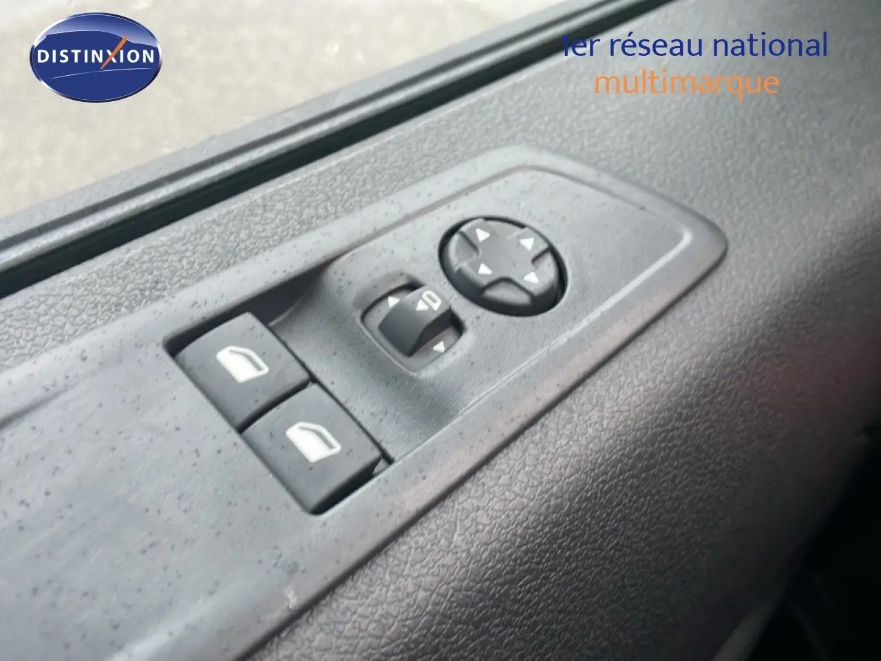 Gros plan sur les commandes de réglage des vitres et des rétroviseurs côté conducteur du Citroën Jumpy gris titane.