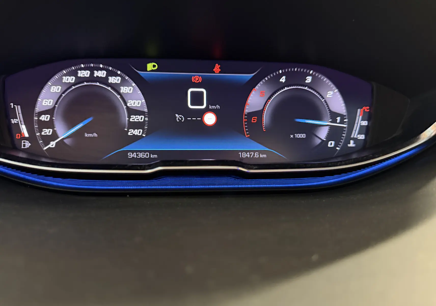 Vue rapprochée du tableau de bord numérique du Peugeot 5008 gris, affichant vitesse et compte-tours.