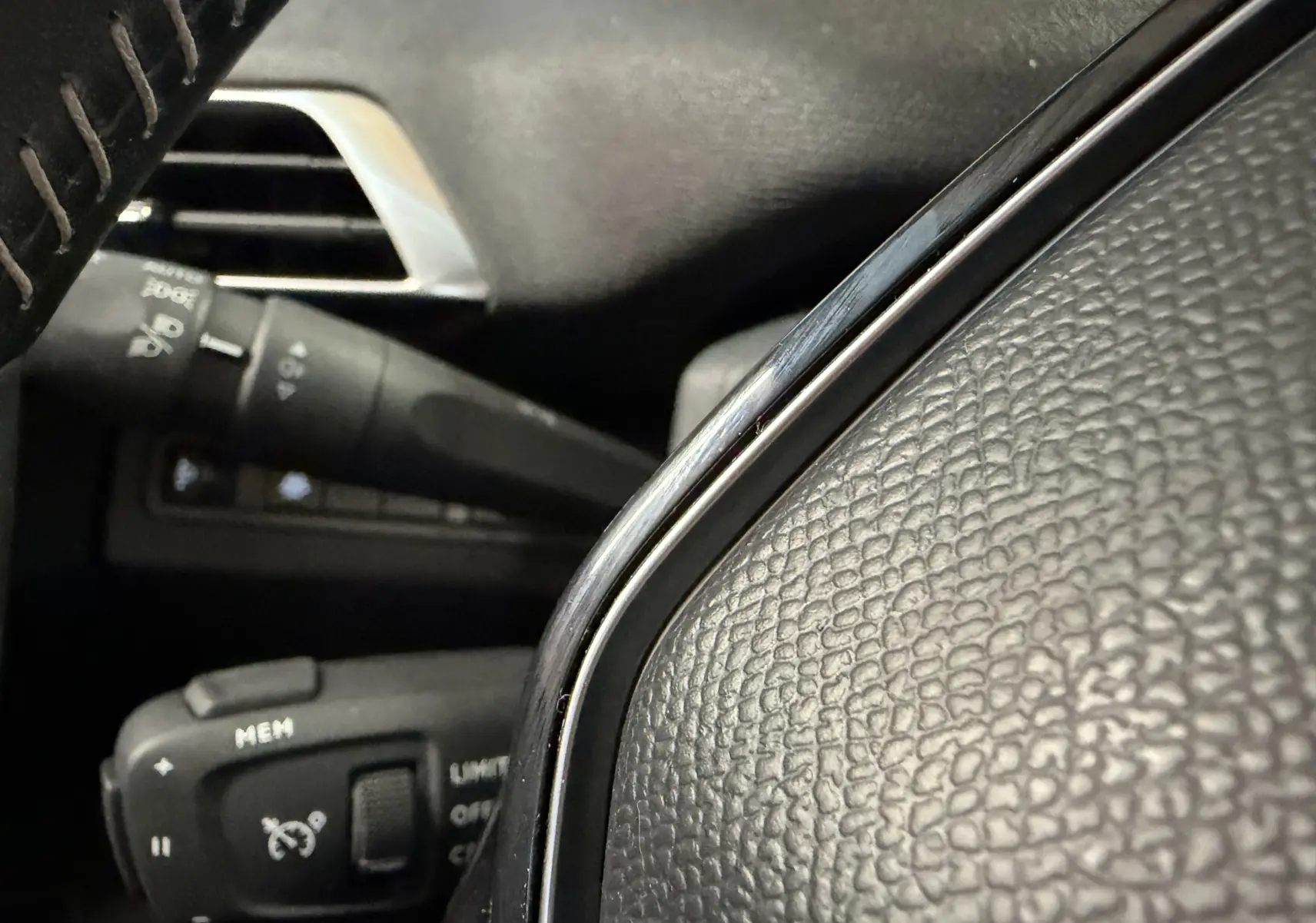 Gros plan sur le volant en cuir noir et les commandes de régulateur de vitesse du Peugeot 5008 1.5 BlueHDi 130 Allure.