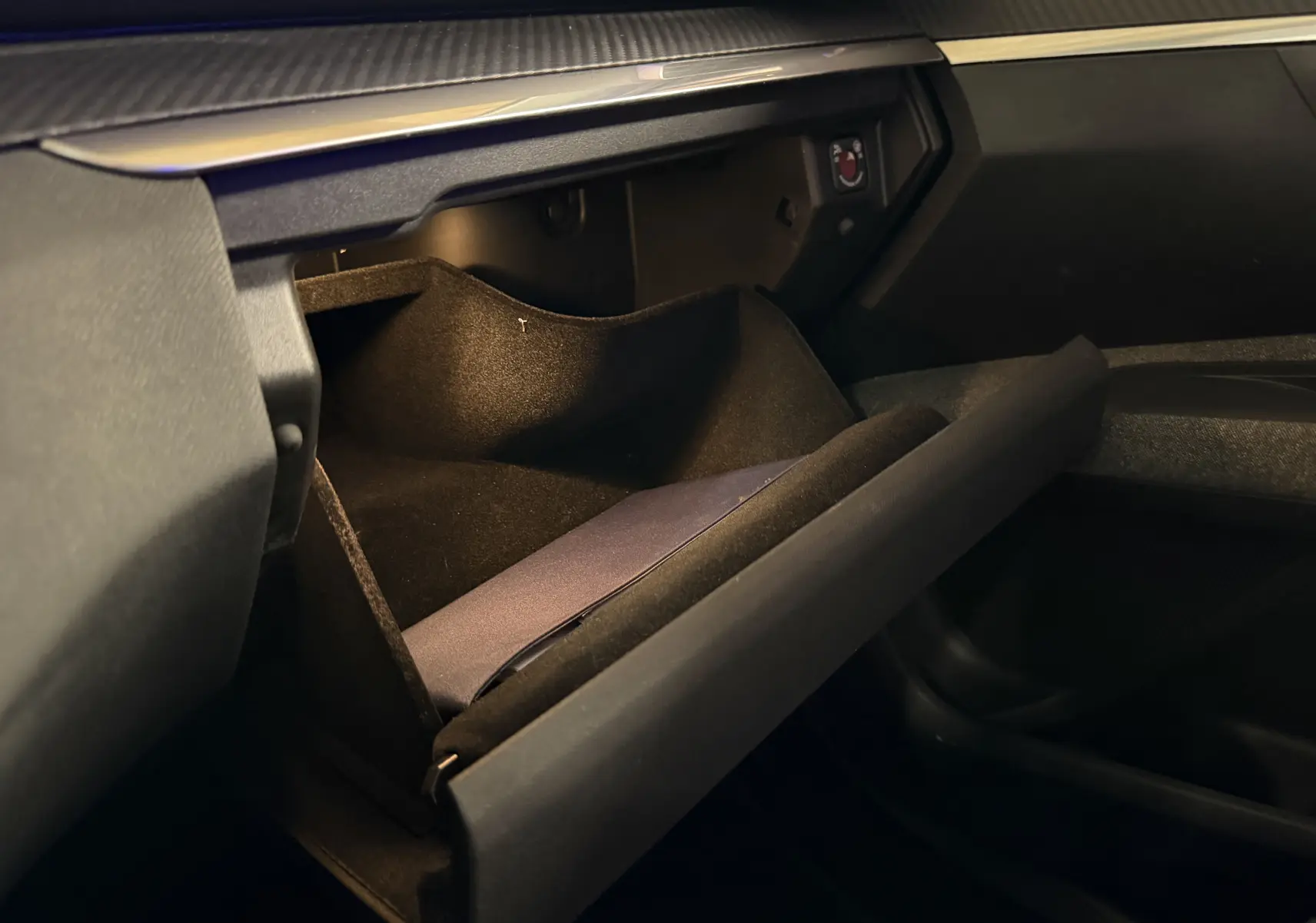 Vue intérieure du coffre à gants ouvert du Peugeot 5008 gris, mettant en valeur son espace de rangement doublé de tissu noir.