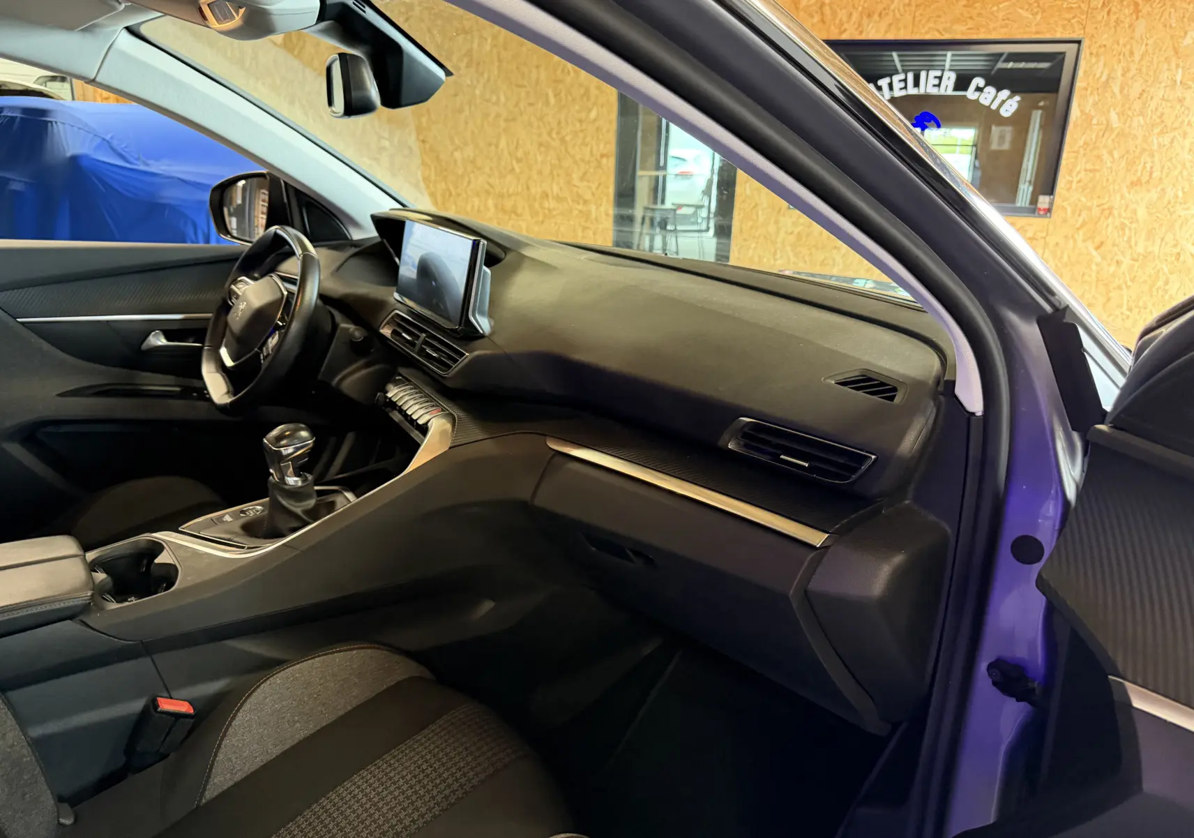 Intérieur avant droit du Peugeot 5008 gris 2021, tableau de bord moderne avec écran tactile et boîte manuelle.