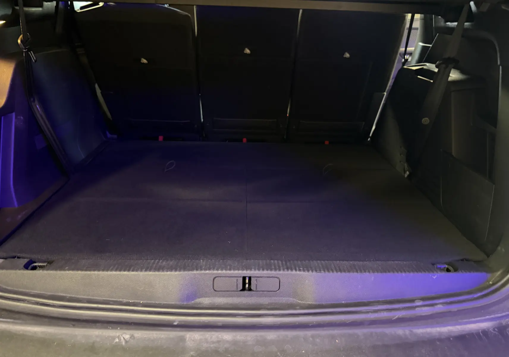 Coffre ouvert en vue arrière d'un Peugeot 5008 gris 1.5 BlueHDi 130 Allure avec banquette arrière rabattue et intérieur noir.