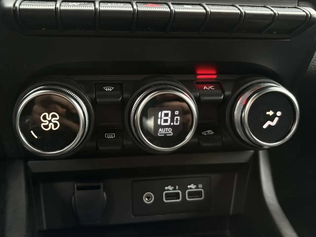 Gros plan sur les commandes de climatisation automatique du Renault Arkana 2025, avec affichage digital à 18°C.