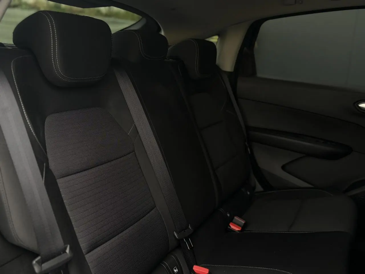Vue intérieure sur la banquette arrière noire avec appuie-têtes et ceintures de sécurité du Renault Arkana 2025.