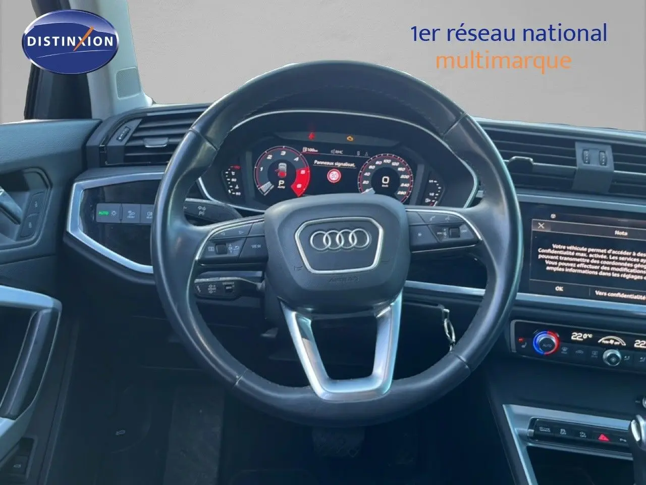 Vue intérieure centrée sur le volant noir et le tableau de bord digital de l'Audi Q3 Sportback 35 TDI 2022.